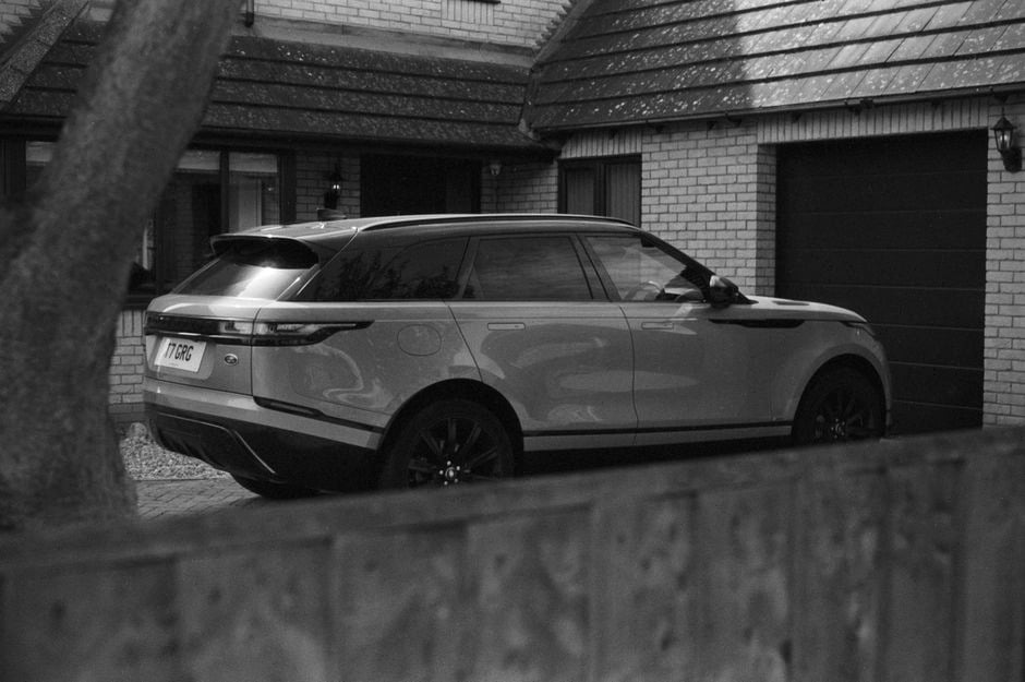 SUV électrique familial chargé devant une maison contemporaine